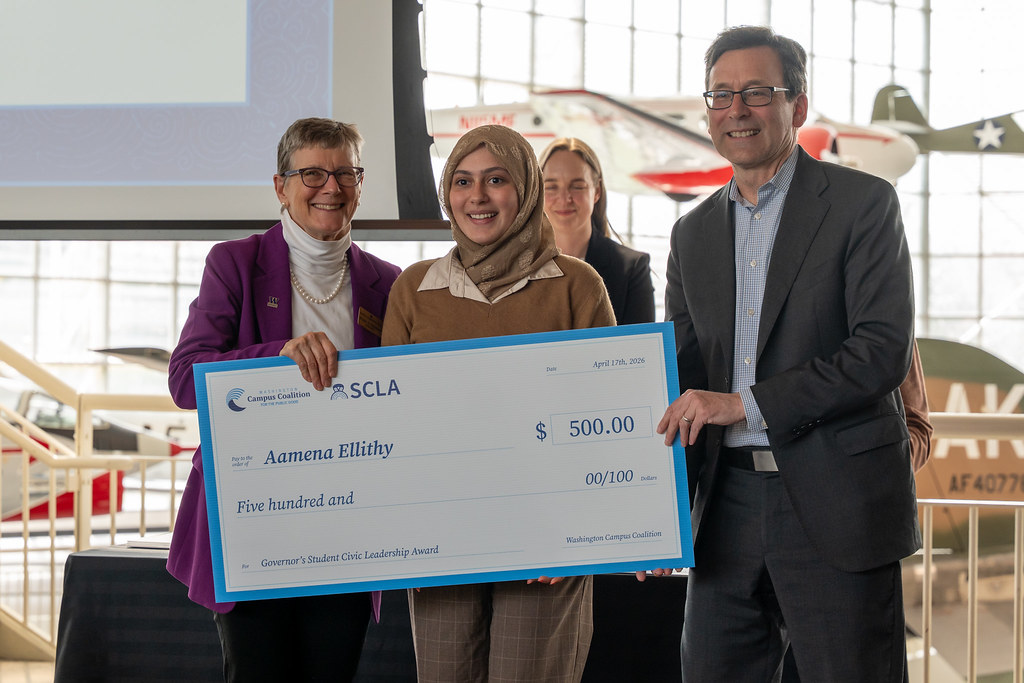 A group of people holding a large check for $500.