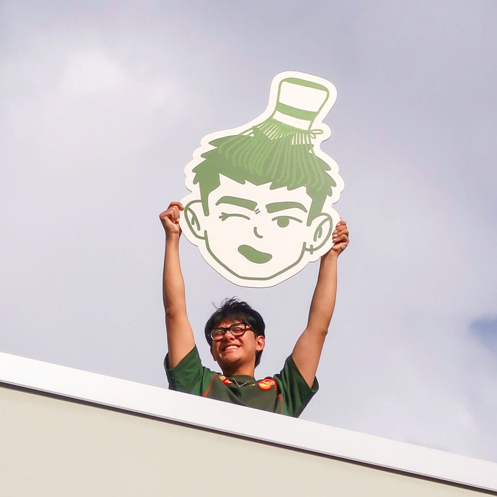 A person holding a sign with a logo on it.