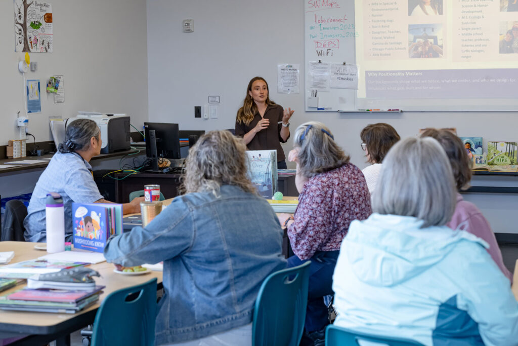 A person speaking to a classroom of people.