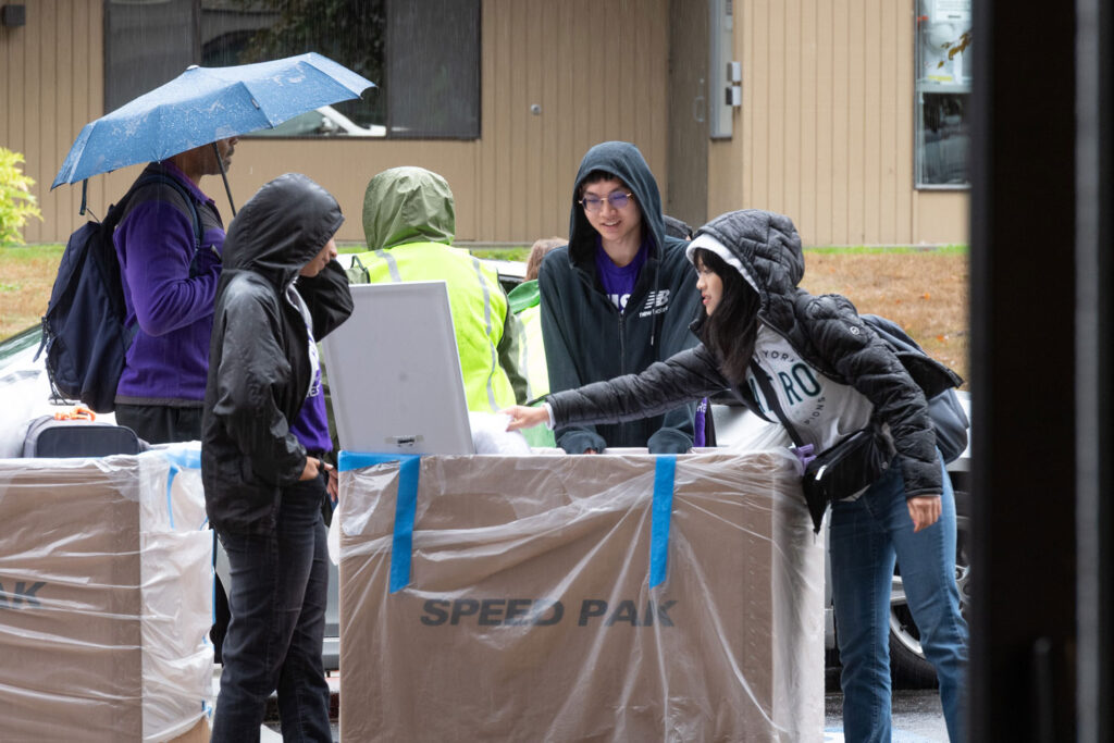 People pushing large boxes.