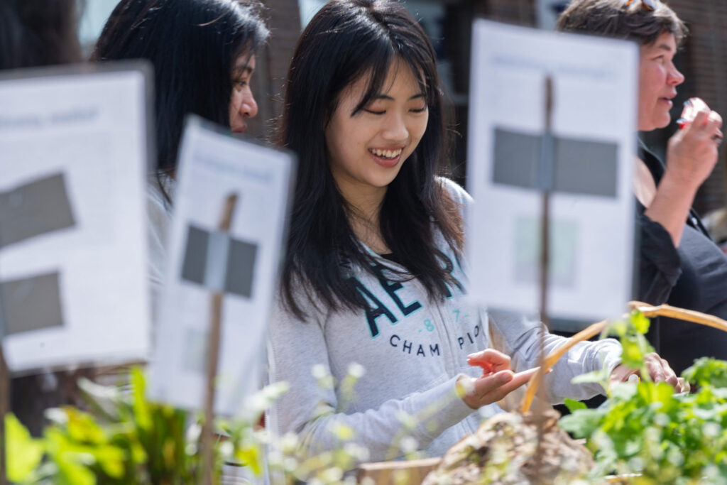 A close-up of a person pointing at plants.