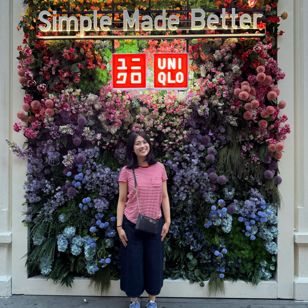 A person standing in front of a sign for "Uniqlo."