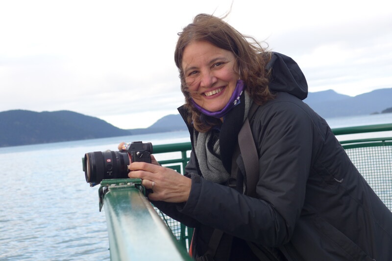 A person holding a camera on a ferry.