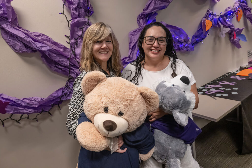 Two people holding stuffed animals.