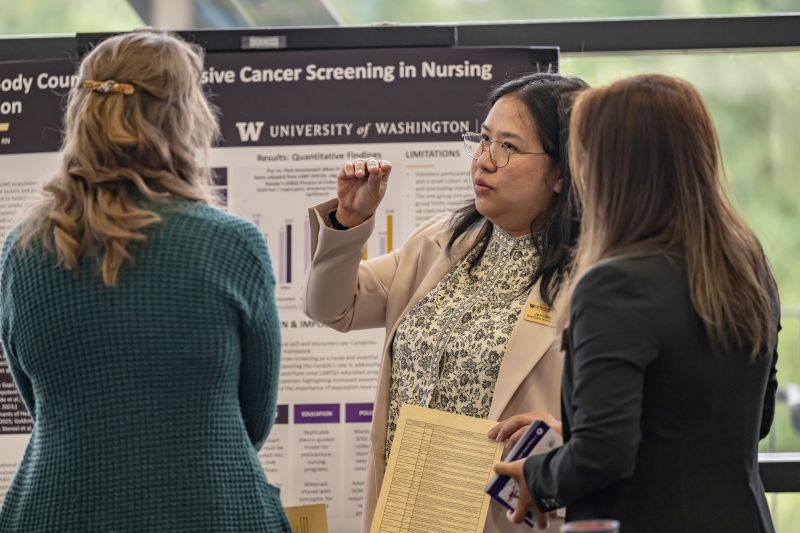 student presenting poster to faculty and partners