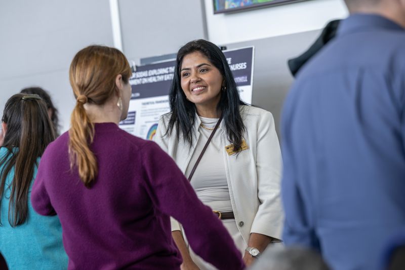 student presenting poster to faculty and partners
