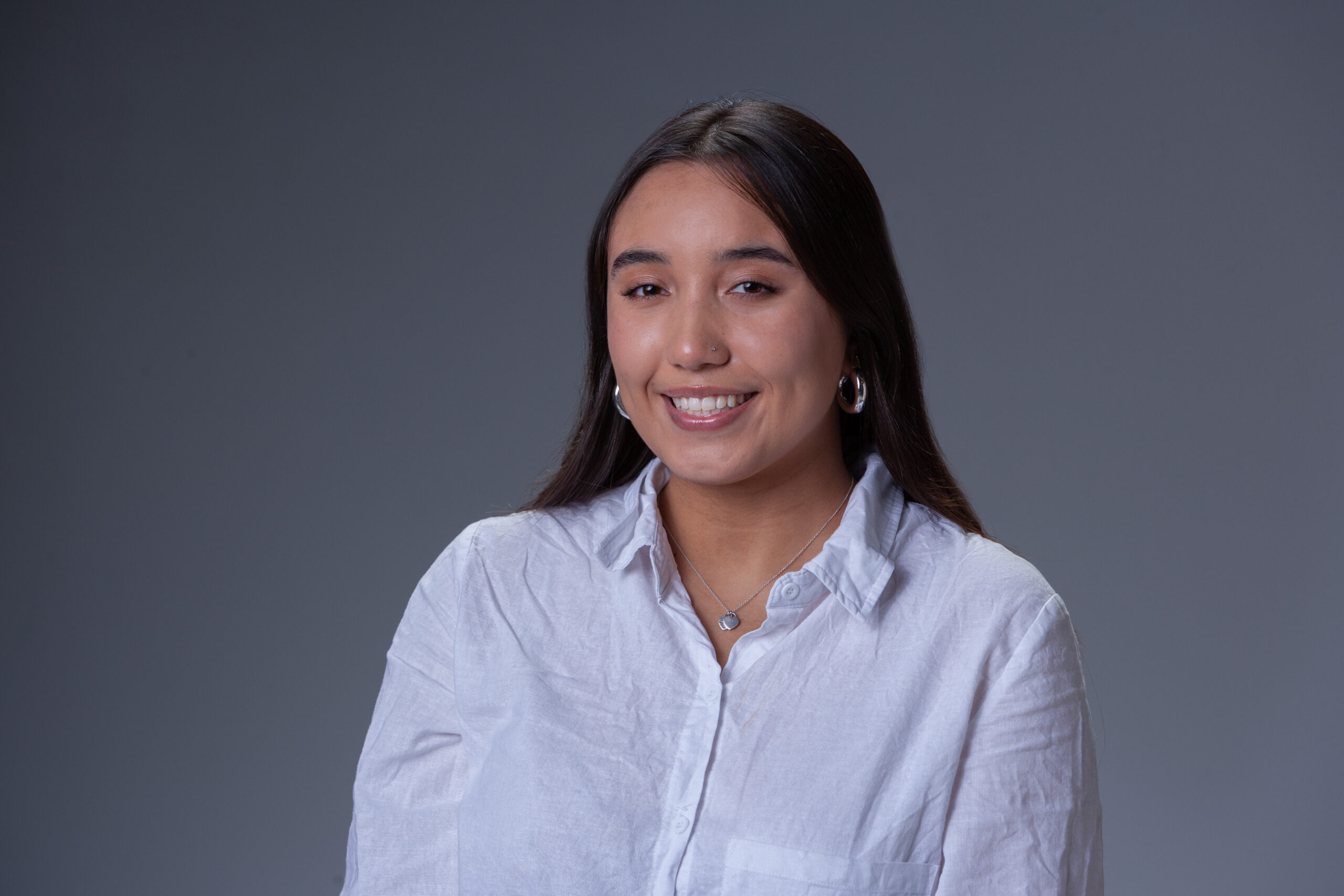 Peer Coach Intern Ava in front of a gray background