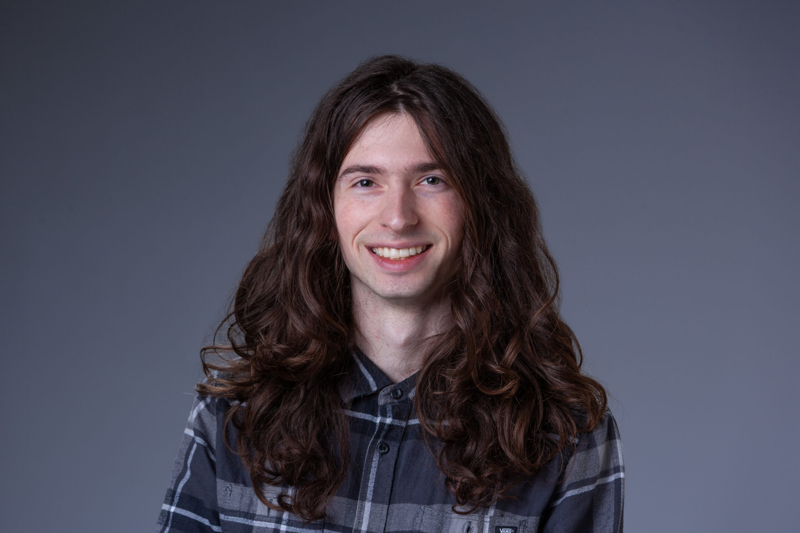 Orientation Intern Rafferty in front of a gray background