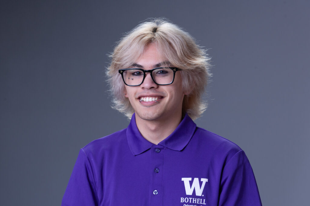 Peer Coach Jacob in a purple polo in front of a gray background
