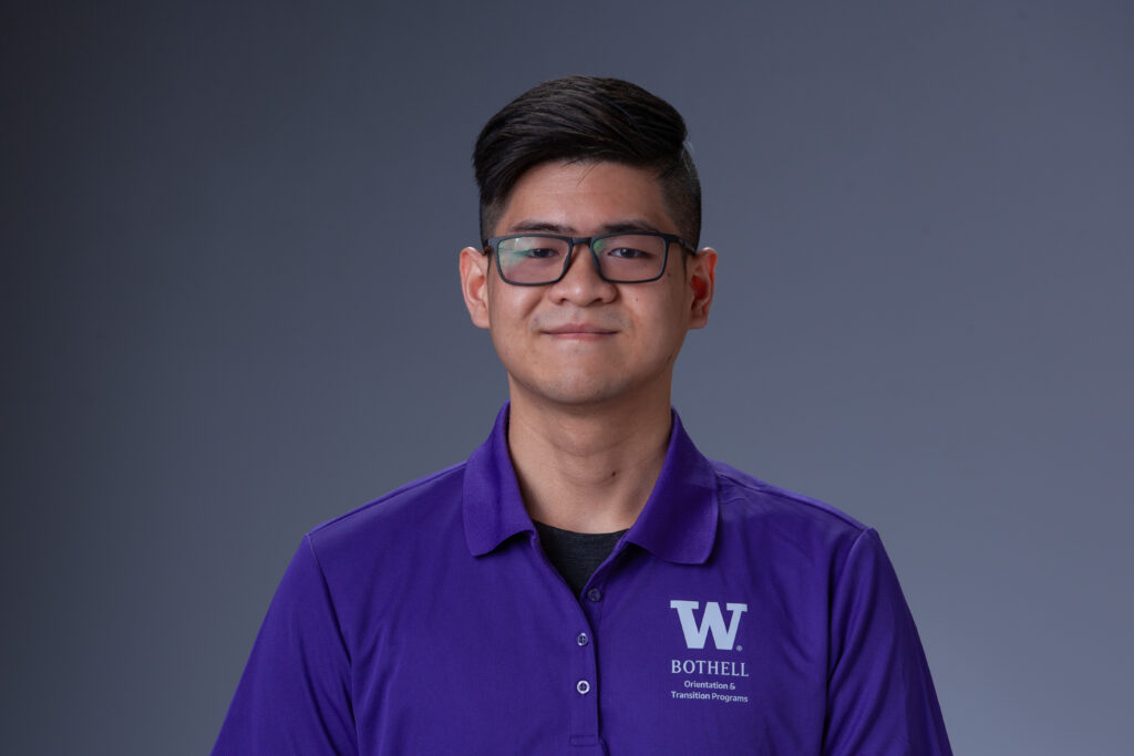 Peer Coach Khoa in a purple polo in front of a gray background