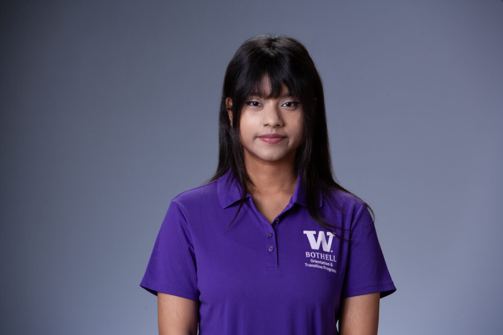 Peer Coach Roshia in a purple polo in front of a gray background