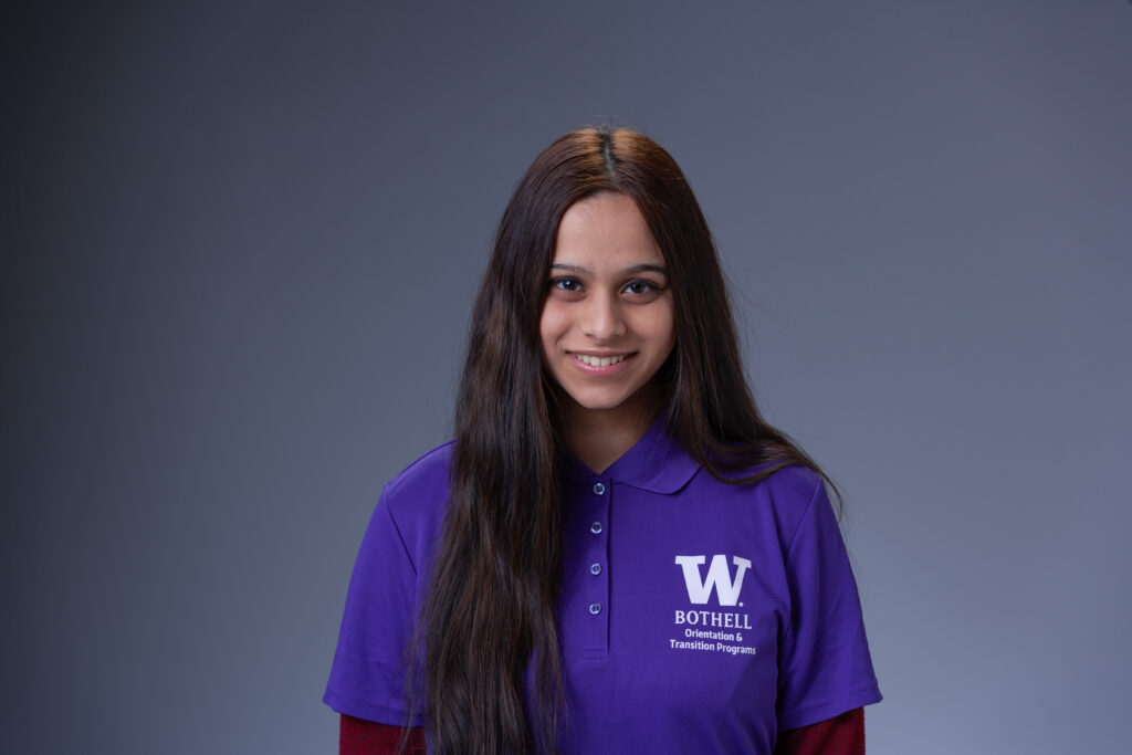 Peer Coach Samiha in a purple polo in front of a gray background