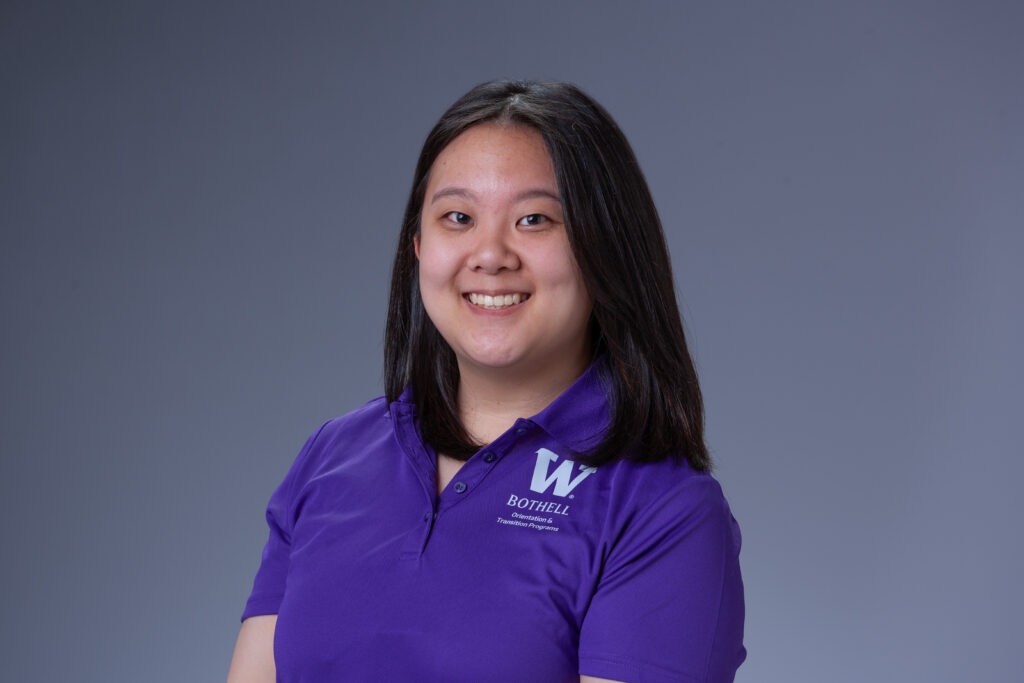 Peer Coach Shanna in a purple polo in front of a gray background