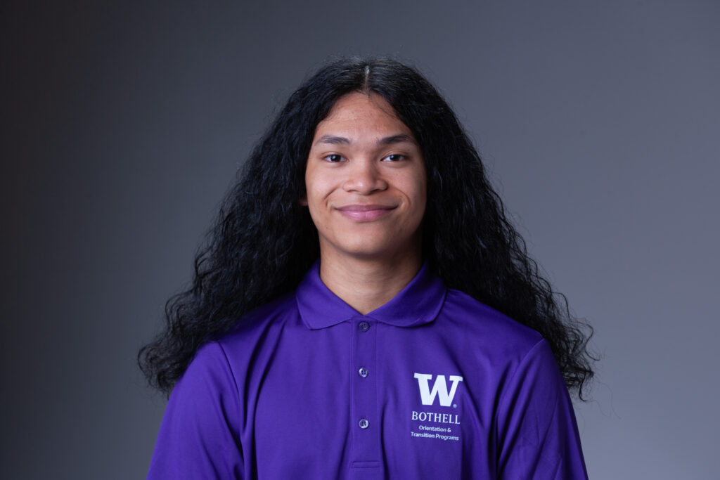 Peer Coach Ygghyvonne in a purple polo in front of a gray background