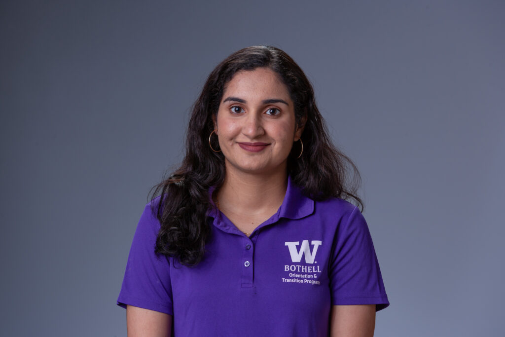 Peer Coach Anushka in a purple polo in front of a gray background