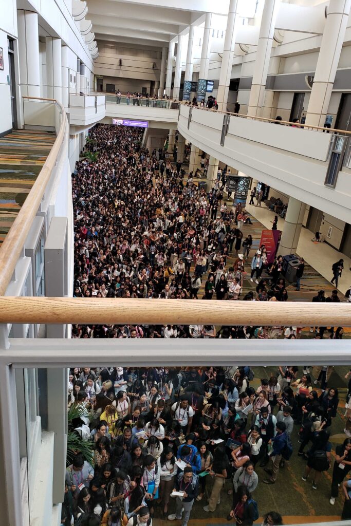 Looking down from the second story balcony to see hundreds of people filling the hall waiting for the expo hall to open.