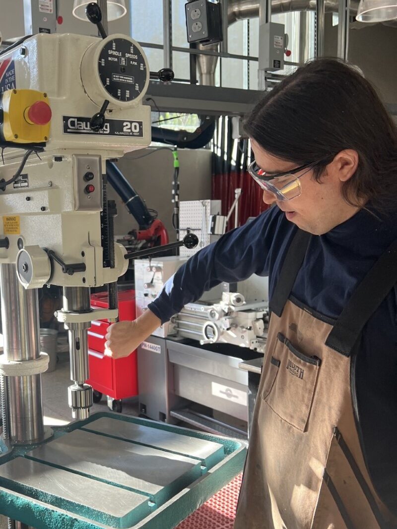 Jacob Roth demonstrating how to use a drill press.