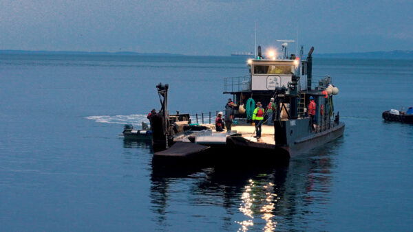 Researchers and crew on a boat prepare for connection and deployment