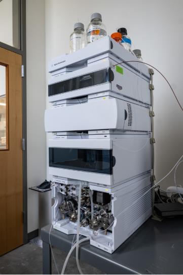 Liquid chromatography system with purging bottles and additional lab equipment attached