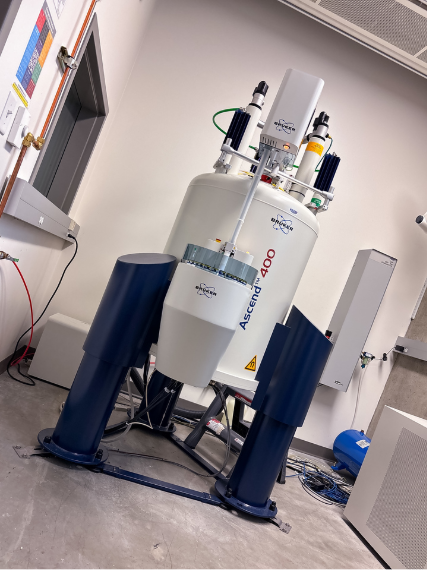 A white and blue spectrometer with a probe and an autosampler in a lab