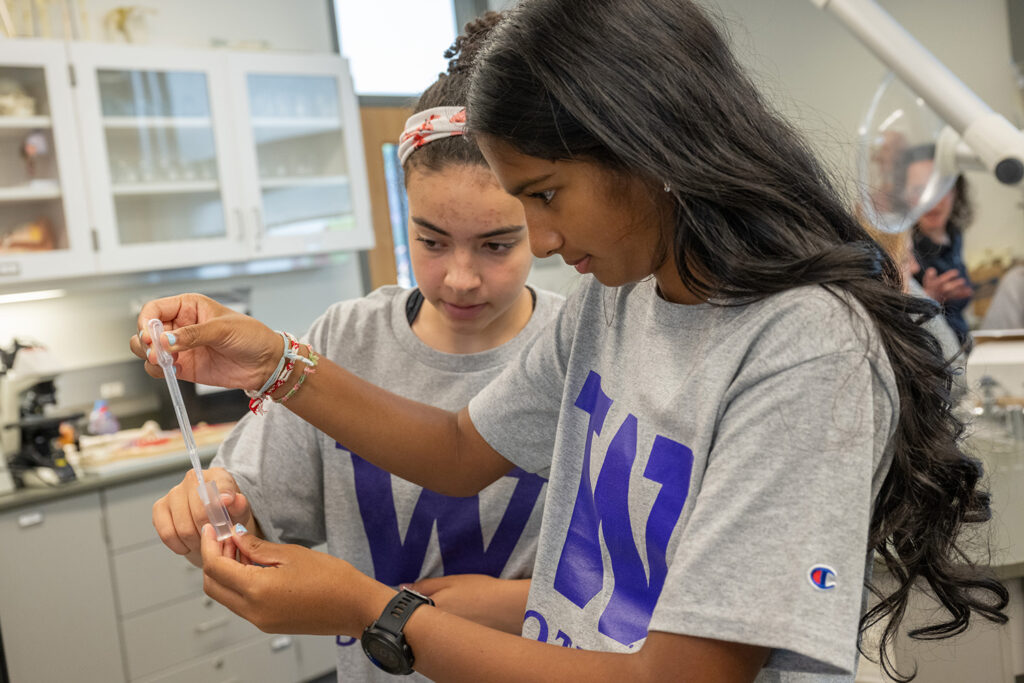 Student uses a pipet to dispense liquid.