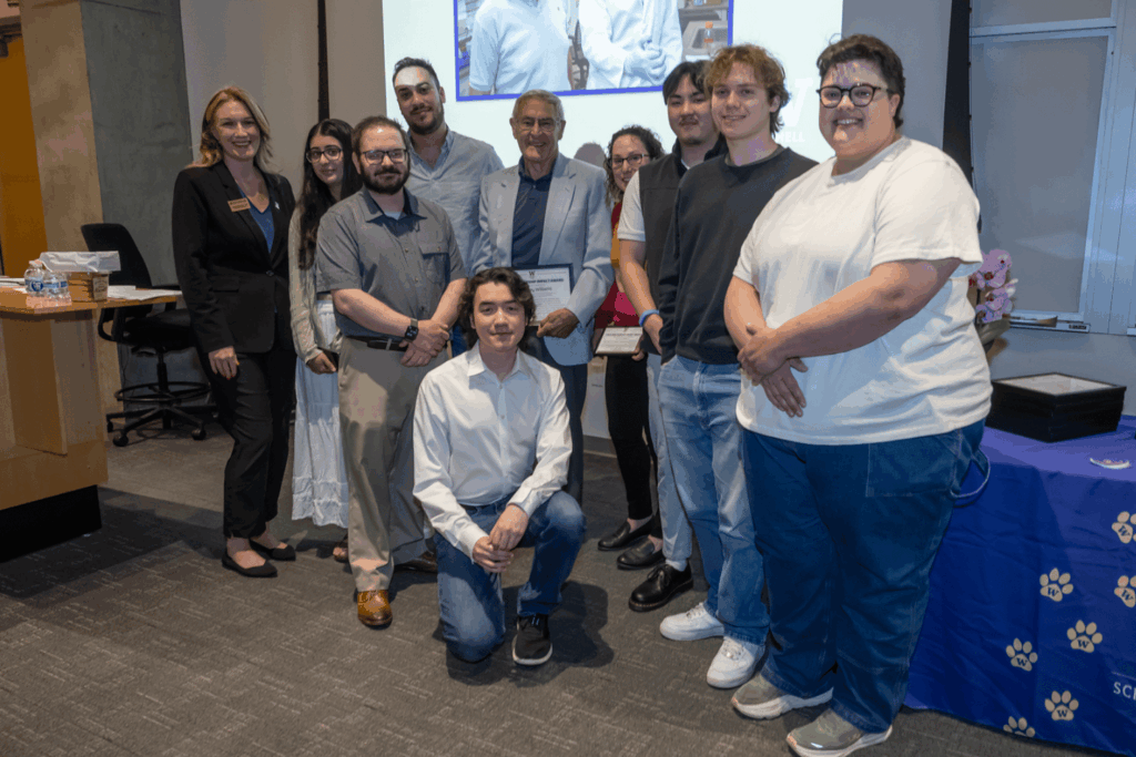 Past and present students who worked with Dr. Jeffrey Williams stand for a group photo at the awards ceremony