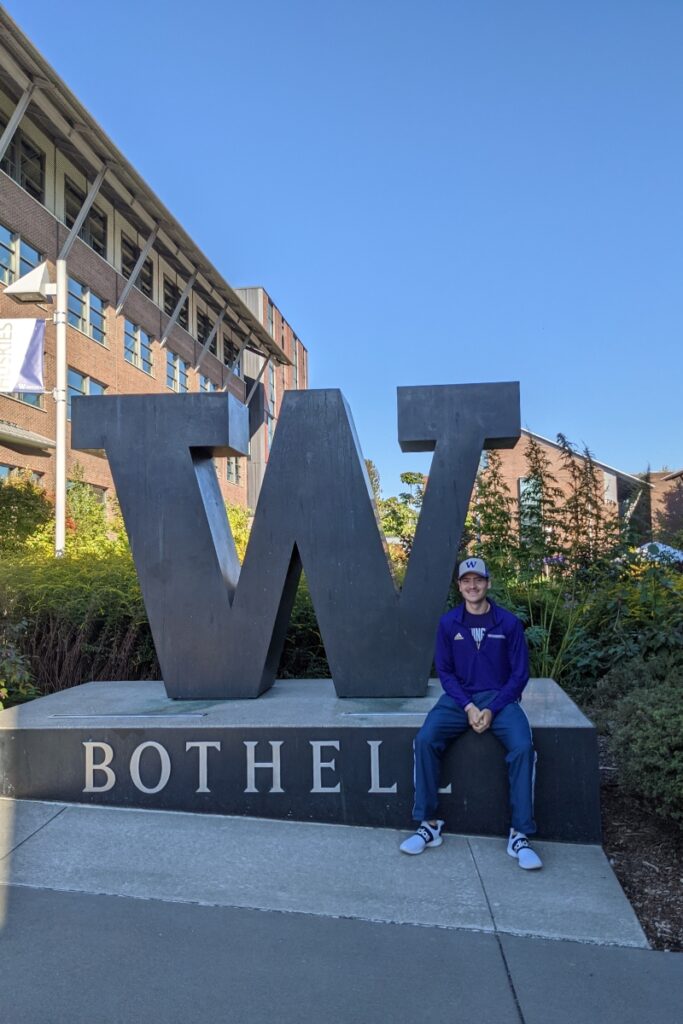 Bruno sits in front of the W sign at UW Bothell on his first day.