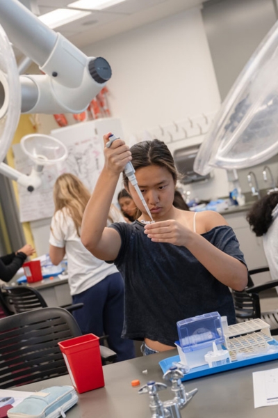 Student holding a pipette in a lab