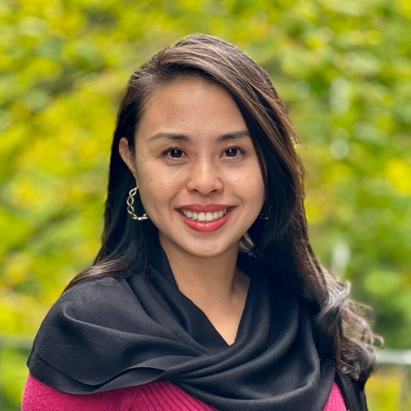 Asian woman with long black hair wearing a red sweater and a black shawl.