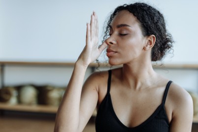 woman breathing with thumb closing one nostril
