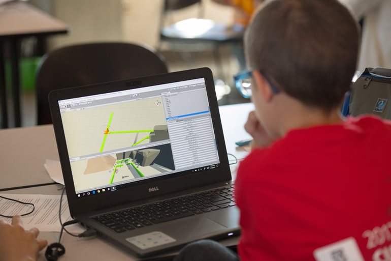 Boy working on laptop during VR camp