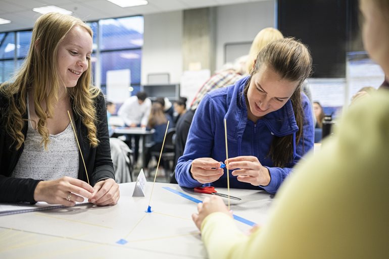 Students build with sticks of spaghetti.