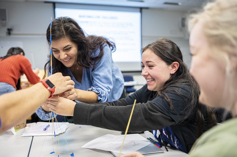 Students build with sticks of spaghetti.