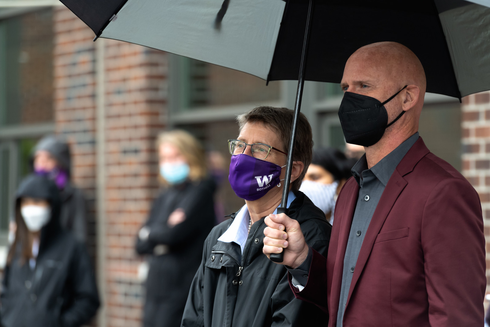 UW Bothell Chancellor Kristin Esterberg and Cascadia College President Eric Murray under an umbrella observing the event