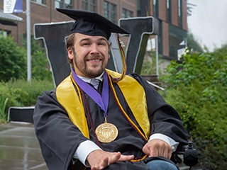 portrait of chris hays in front of the "W" statue