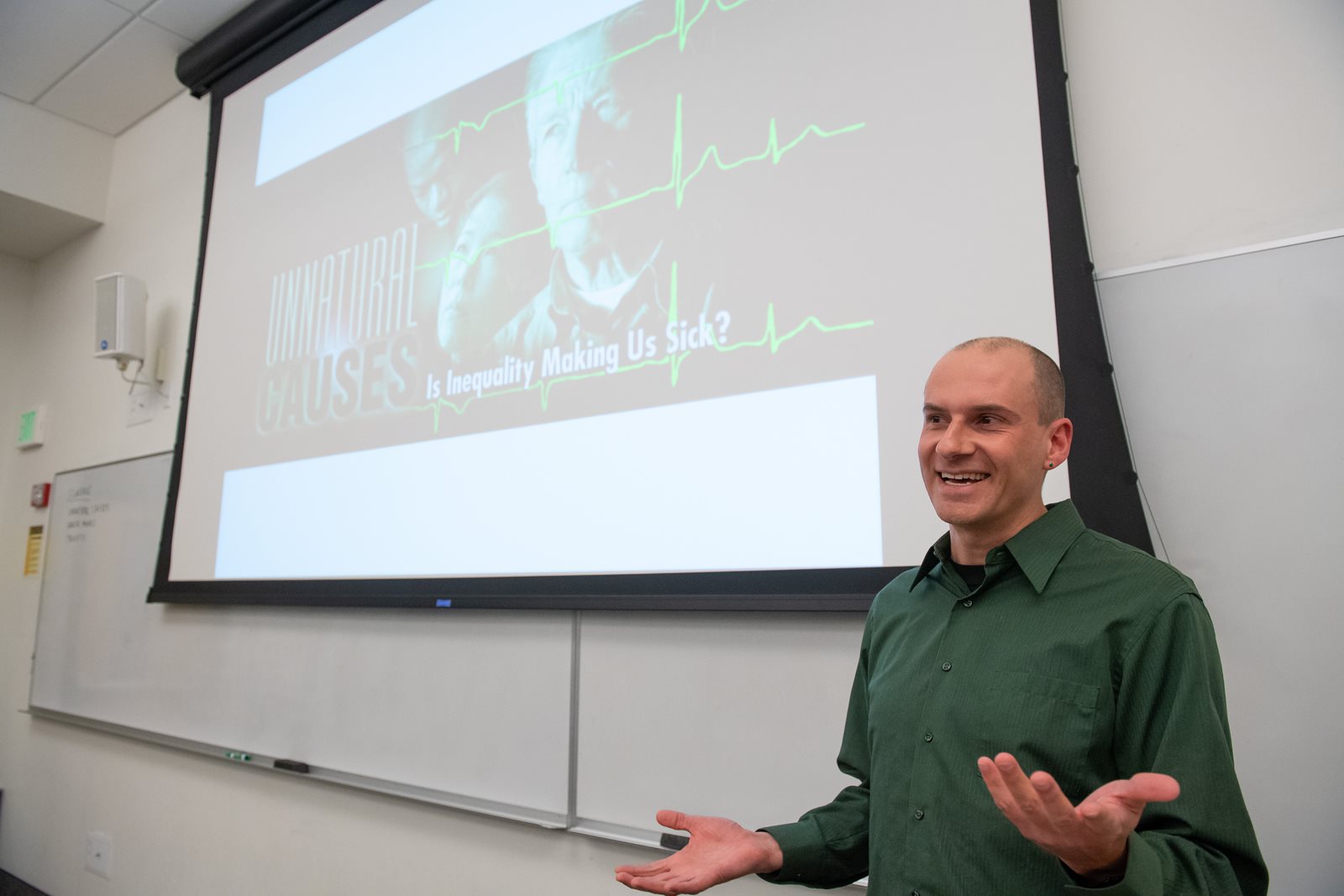 Chris Wade teaching in class in front of screen.