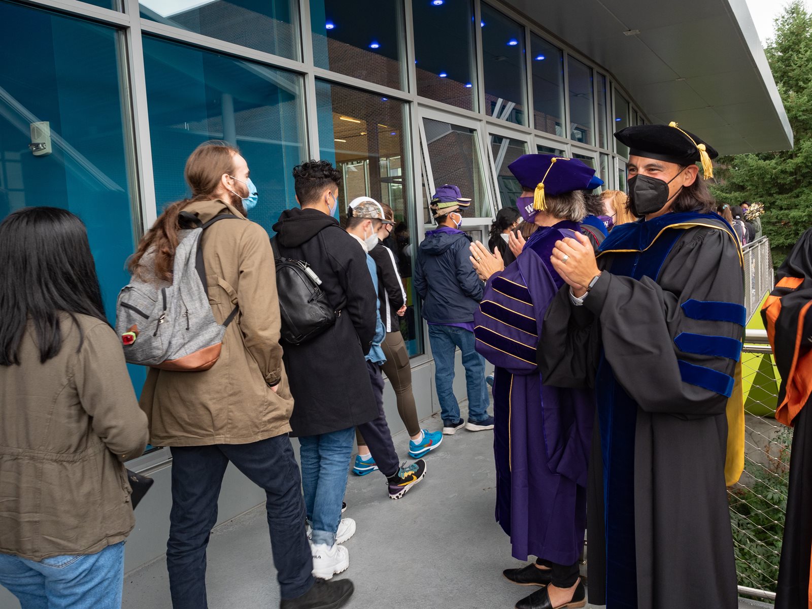 Faculty clapping for students as they walk by