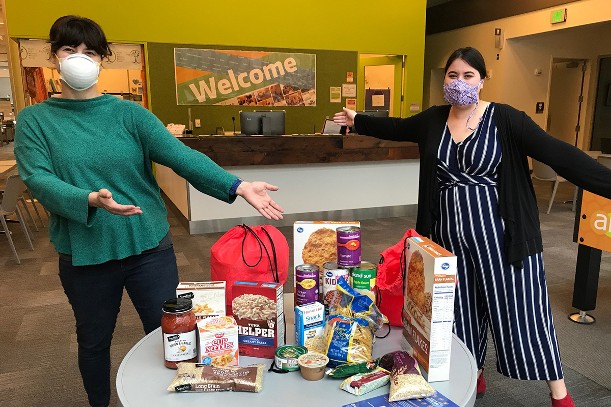 Two students pictured with Husky Pantry food
