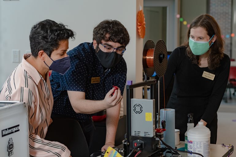 Jesus Govella and Kara Adams examining items made with 3D printers 