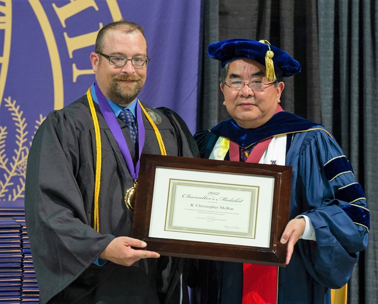 McRae receiving Chancellor's Medal from Kenyon Chan in 2012. 