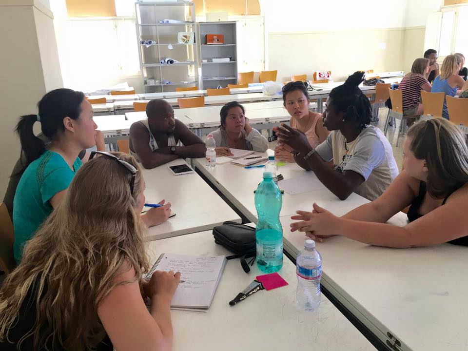 students, migrants around table