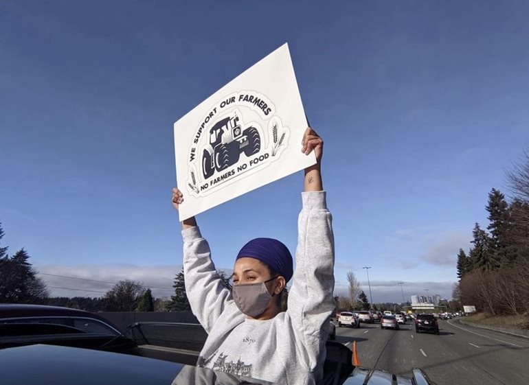 Sharndeep Shoker holding sign to protest the 2020 farm bills in India