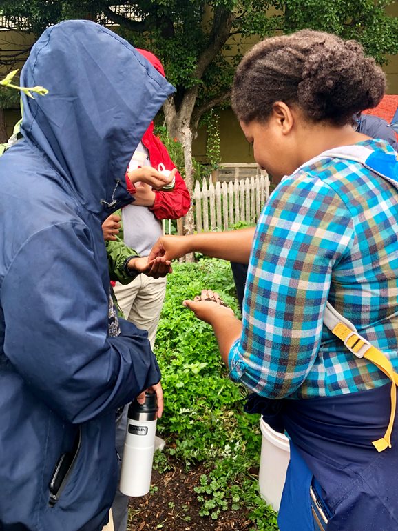 Melanie Malone and student holding soil.