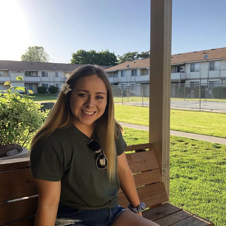 Desirae Vega smiling on a park bench