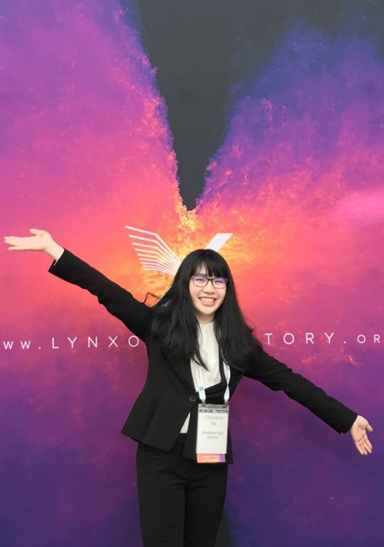 Christine Ye posing in front of painted purple wings 